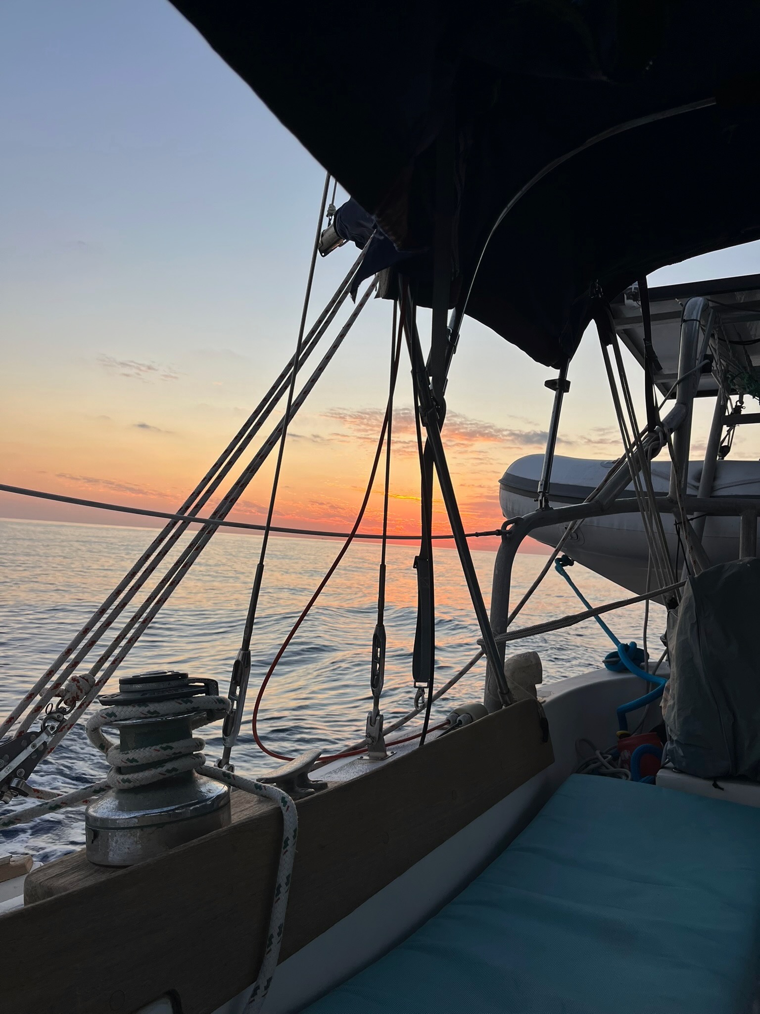 Sunset view from the cockpit underway, dinghy on davits