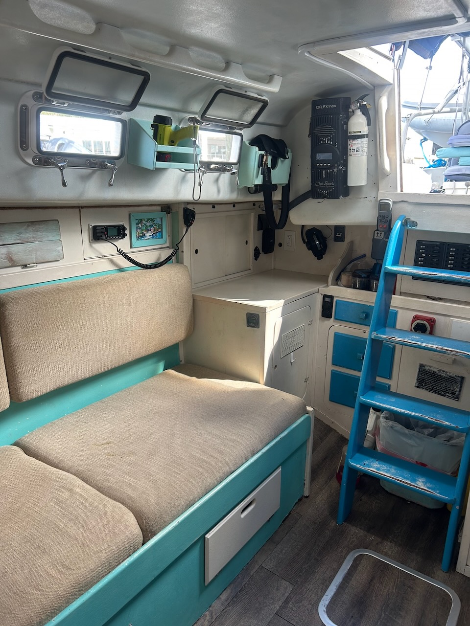 Salon looking aft toward the companionway ladder, settee, and nav station